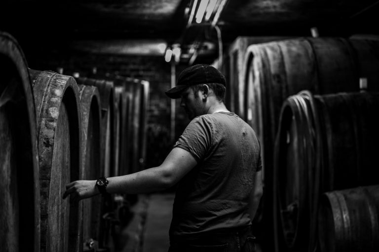 Mann geht durch Reihen mit Weinfässern von Terra Preta Weingut Rheinhessen
